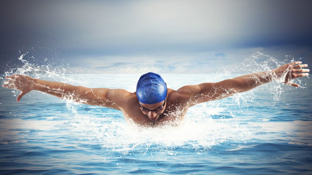 Swimmer with swimming cap and goggles in the ocean