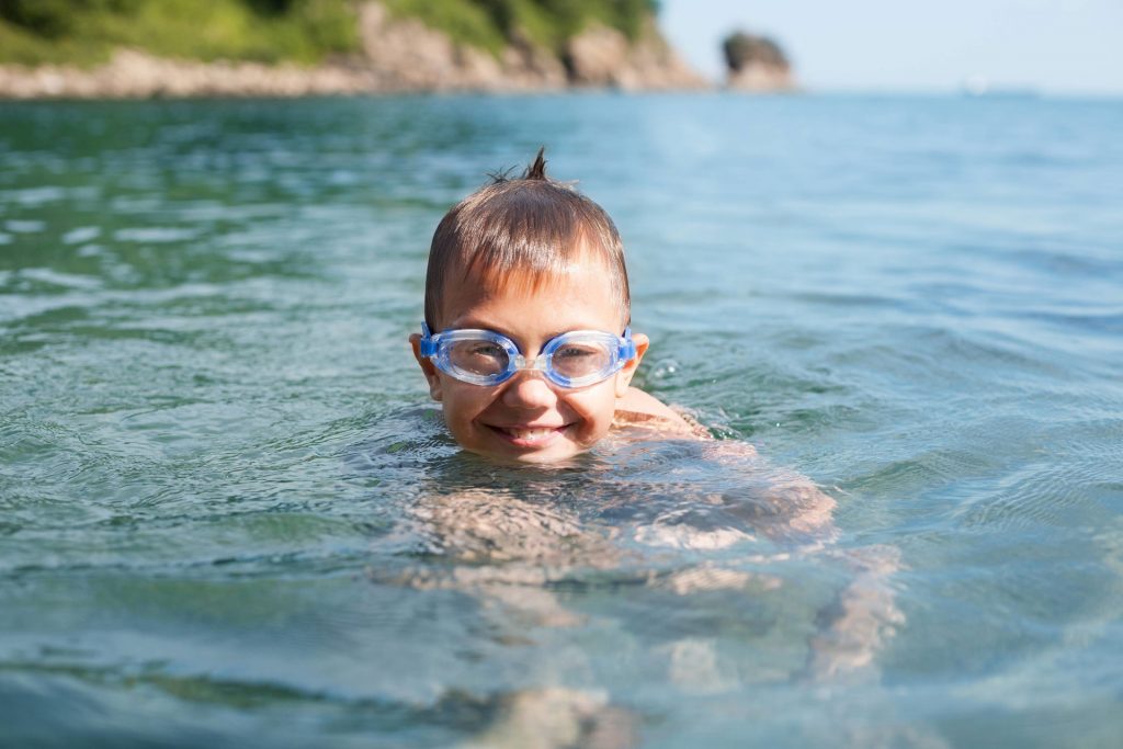 Boy with goggles treading water