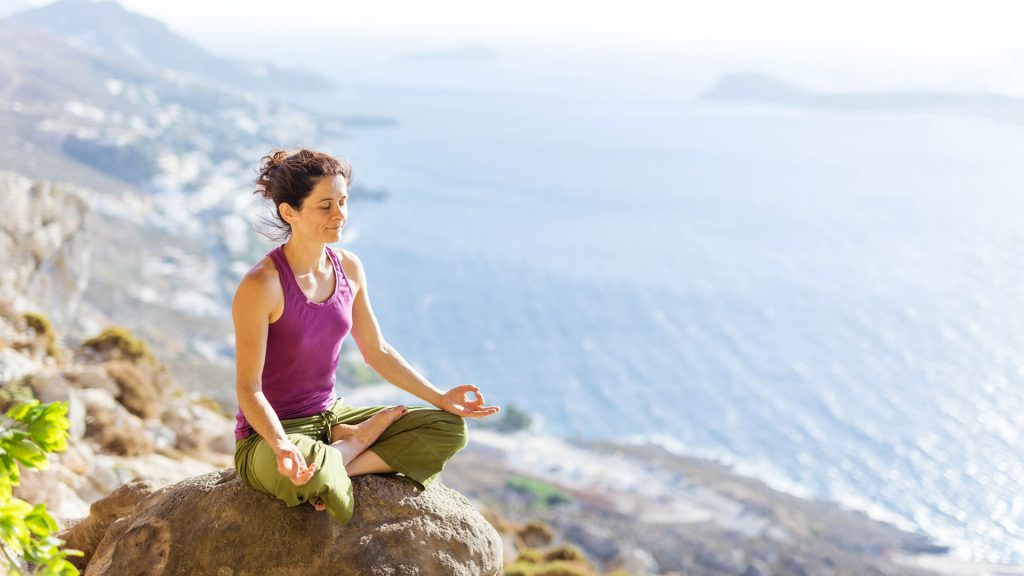 Woman meditating on a mountain