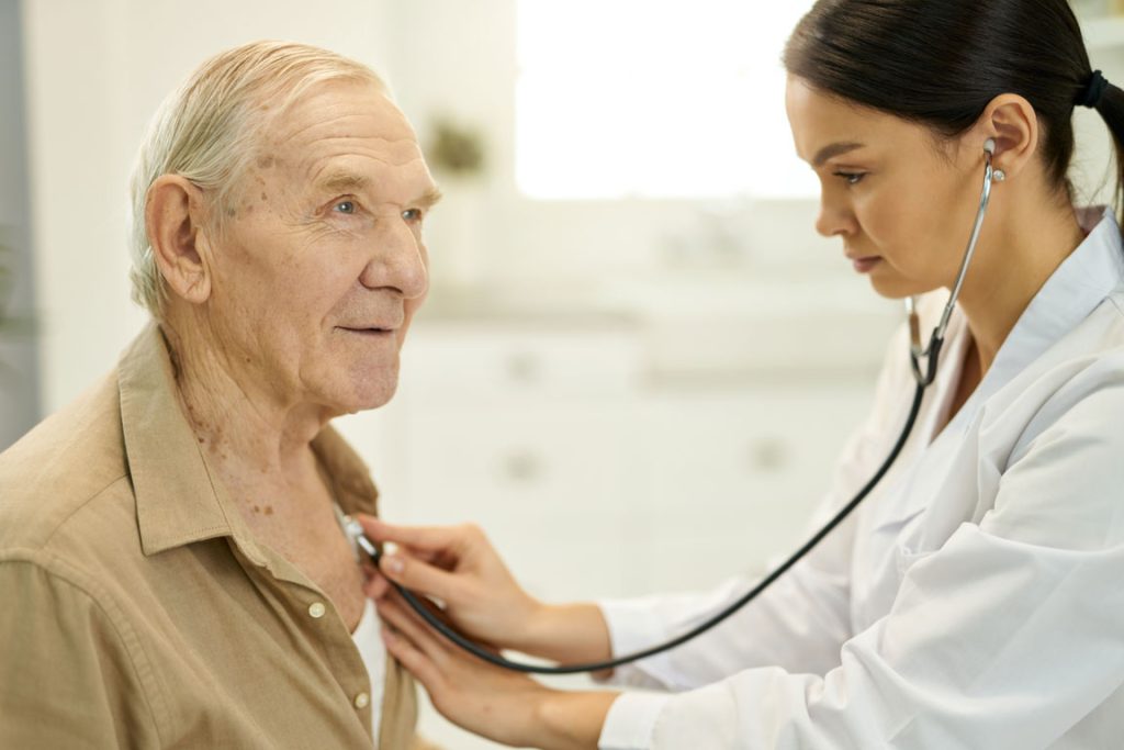 doctor checking senior male's heart