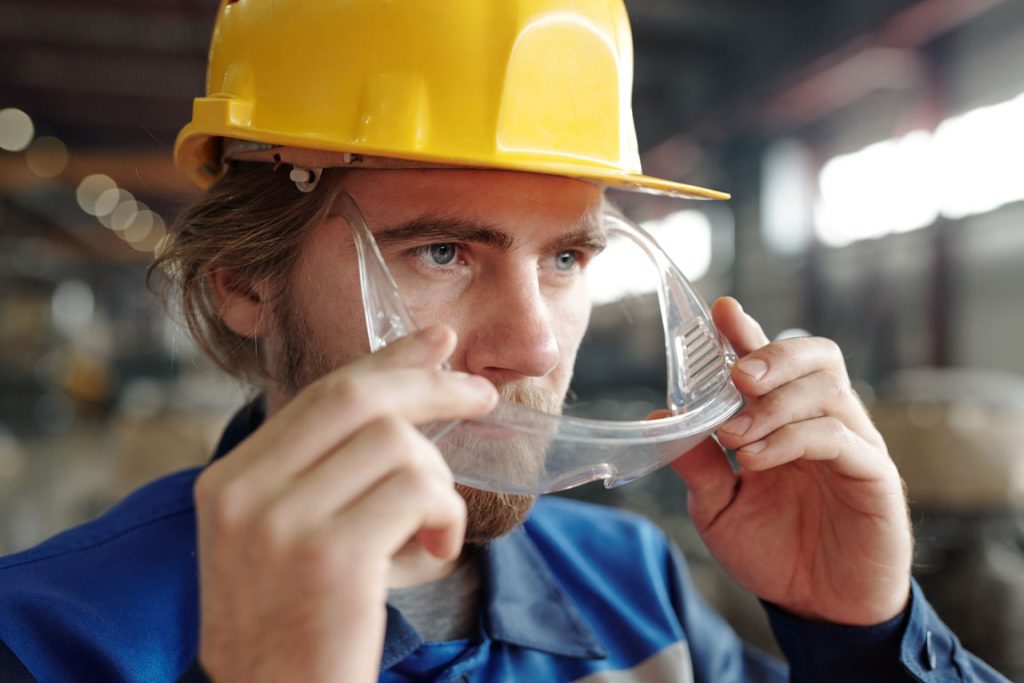 construction worker putting on safety goggles