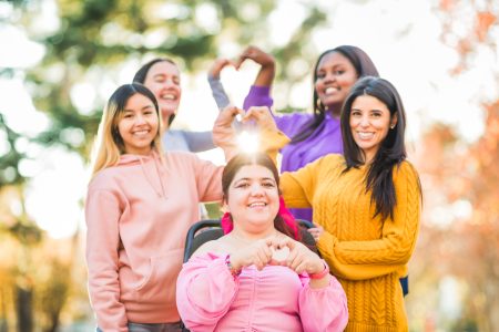 Inspire Inclusion international womens day. Diverse group do heart love with hands. Disability 5 women making heart hands
